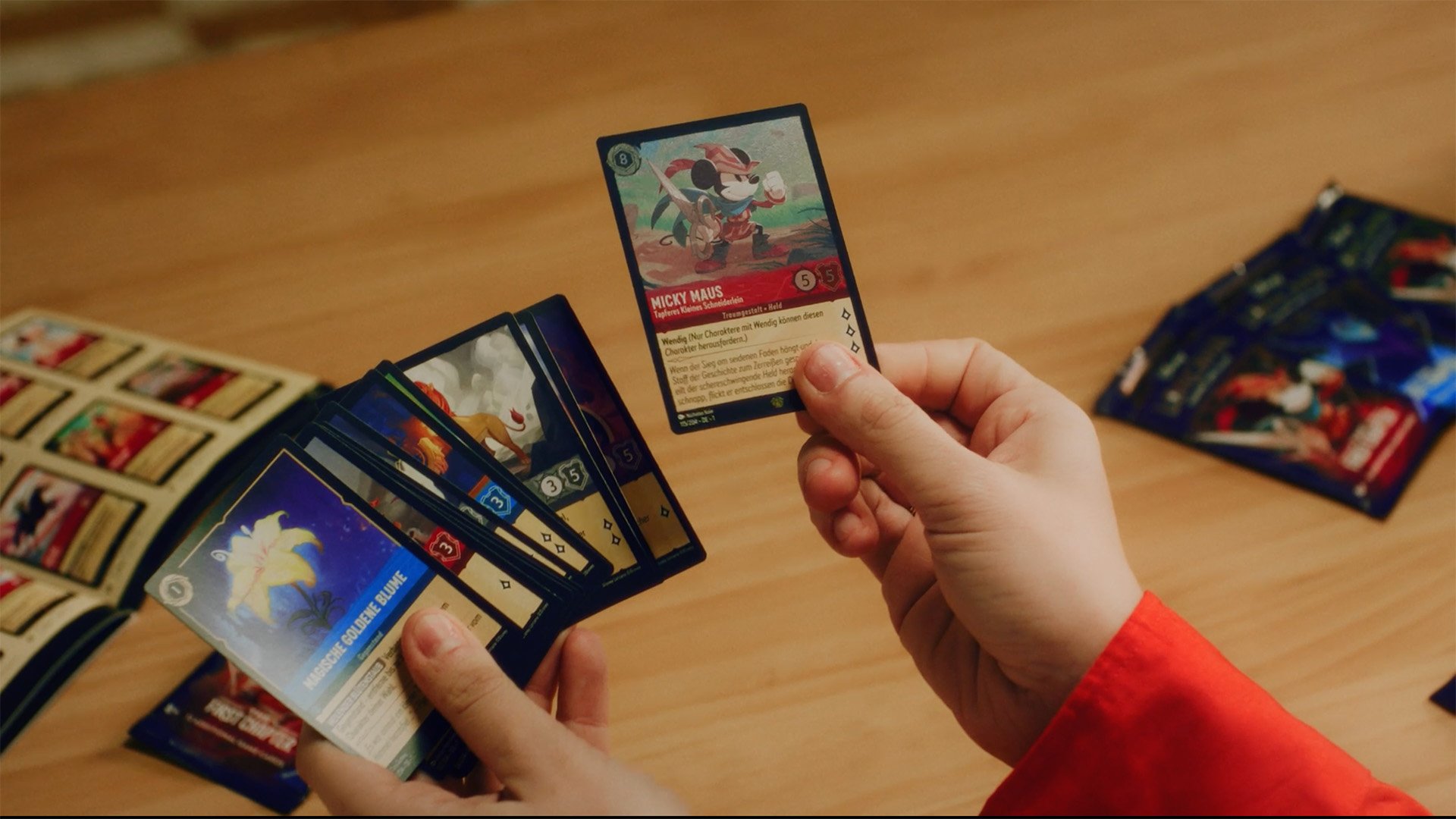 Image of a woman's hands holding Disney Lorcana cards